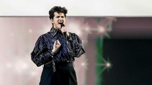 Junger Musiker singt voller Inbrunst auf der Bühne am 65. Eurovision Song Contest. Junger Musiker singt voller Inbrunst auf der Bühne am 65. Eurovision Song Contest.
