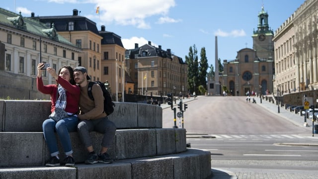 Praktisch menschenleerer Platz in Stockholm, zwei Personen machen ein Selfie.