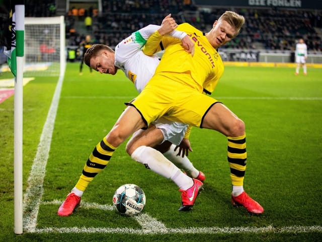 Haaland an der Eckfahne in einem zweikampf um den Ball
