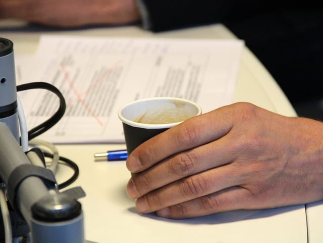 Pedro Lenz hält einen Kaffeebecher.