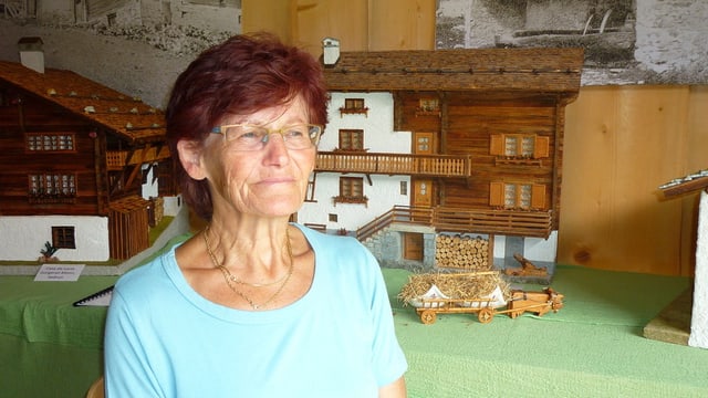 Maria Cavegn davant ina da las chasas en miniatura. Maria Cavegn davant ina da las chasas en miniatura.