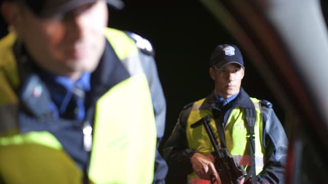Zwei Polizisten. Einer hät ein Maschinengewehr. Zwei Polizisten. Einer hät ein Maschinengewehr.