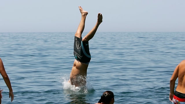 Person, welche im Wasser einen Handstand macht. Die Füsse bleiben am trockenen. Person, welche im Wasser einen Handstand macht. Die Füsse bleiben am trockenen.