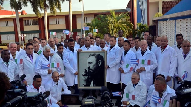 Kubanische Ärzte posieren mit Bild von Fidel Castro