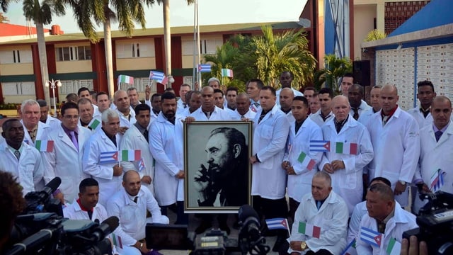 Kubanische Ärzte posieren mit Bild von Fidel Castro Kubanische Ärzte posieren mit Bild von Fidel Castro