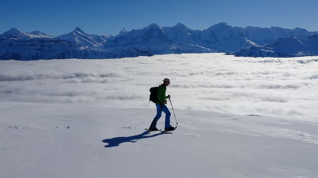 Ein Berggänger marschiert über das Schneefeld auf dem Burgfeldstand bei gleisendem Sonnenschein. Ein Berggänger marschiert über das Schneefeld auf dem Burgfeldstand bei gleisendem Sonnenschein.