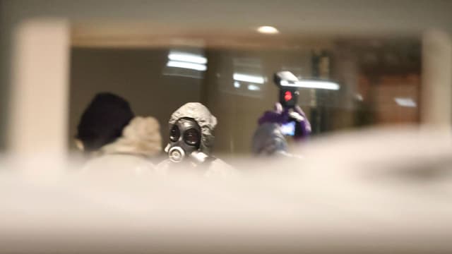 Männer mit Gasmasken untersuchen den Tatort. Männer mit Gasmasken untersuchen den Tatort.