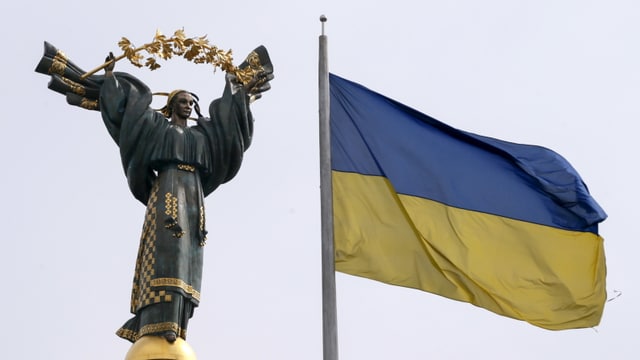 Das Unabhängigkeitsdenkmal sowie die Flagge der Ukraine in Kiew Das Unabhängigkeitsdenkmal sowie die Flagge der Ukraine in Kiew