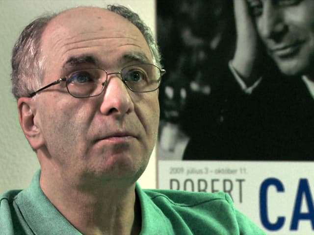 Fotograf Klaus Rosza vor einrm Robert-Capa-Plakat. Fotograf Klaus Rosza vor einrm Robert-Capa-Plakat.