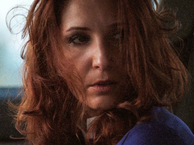Eine Frau blickt erstaunt. Sie hat rotes, unruhiges Haar. Eine Frau blickt erstaunt. Sie hat rotes, unruhiges Haar.