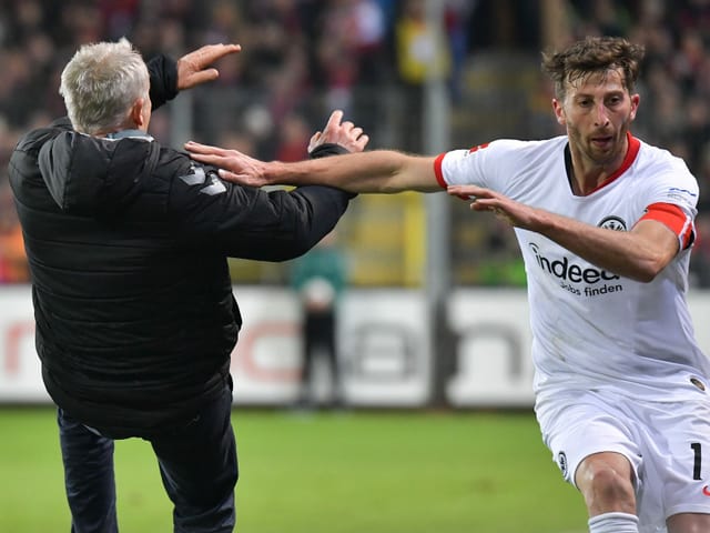 Freiburg-Captain David Abraham rammt Christian Streich. Freiburg-Captain David Abraham rammt Christian Streich.