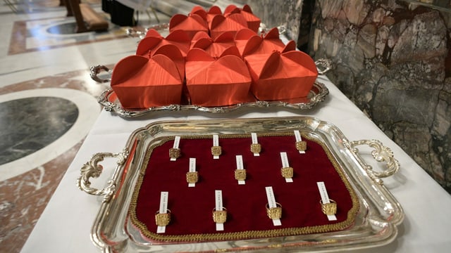 Red hats and rings on a tray.