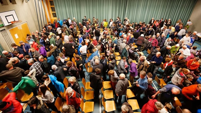Menschen drängen sich in einer Turnhalle Menschen drängen sich in einer Turnhalle