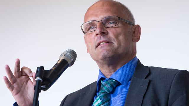 Allfred Heer spricht in ein Mikrofon. Allfred Heer spricht in ein Mikrofon.