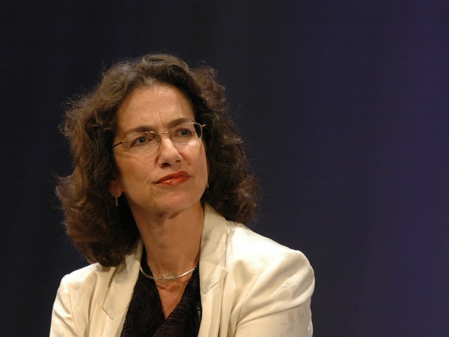 Eine Frau mit schulterlangen Braunen Haaren, Brille und hellem Blazer. Eine Frau mit schulterlangen Braunen Haaren, Brille und hellem Blazer.