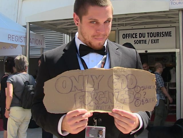 Ein junger Mann im Anzug steht da mit einem Schild in den Händen. Ein junger Mann im Anzug steht da mit einem Schild in den Händen.