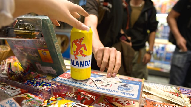 Jugendliche beim Kauf von Alkohol, Identitätskarte neben Bierdose liegend Jugendliche beim Kauf von Alkohol, Identitätskarte neben Bierdose liegend