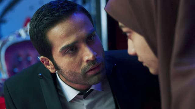 Filmszene: Ein Mann im Anzug redet eindringlich auf eine junge Frau mit Kopftuch ein. Filmszene: Ein Mann im Anzug redet eindringlich auf eine junge Frau mit Kopftuch ein.