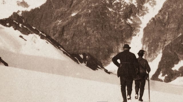 Zwei Bergsteiger auf verschneiter Bergeshöh.