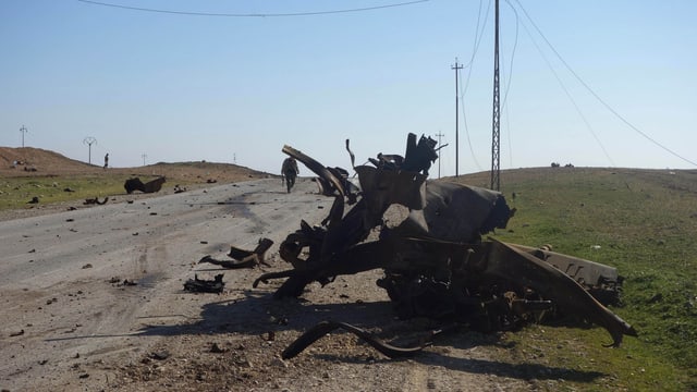 Überreste eines Autos nach einem Bombenanschlag auf einer Strasse von Mossul. Überreste eines Autos nach einem Bombenanschlag auf einer Strasse von Mossul.