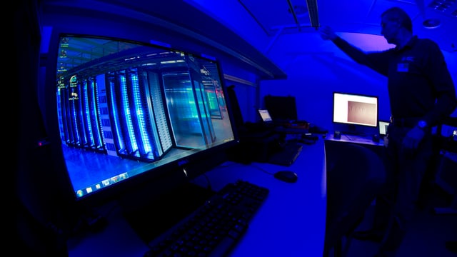 Mann in einem Computerraum mit blauem Licht. Mann in einem Computerraum mit blauem Licht.
