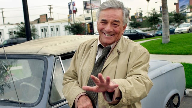 Inspektor Columbo in seinem Trenchcoat vor seinem Peugeot Inspektor Columbo in seinem Trenchcoat vor seinem Peugeot