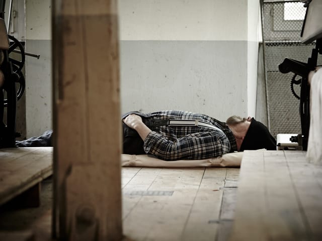 Adriano Geiger döst auf Holzboden in der Fabrik Adriano Geiger döst auf Holzboden in der Fabrik