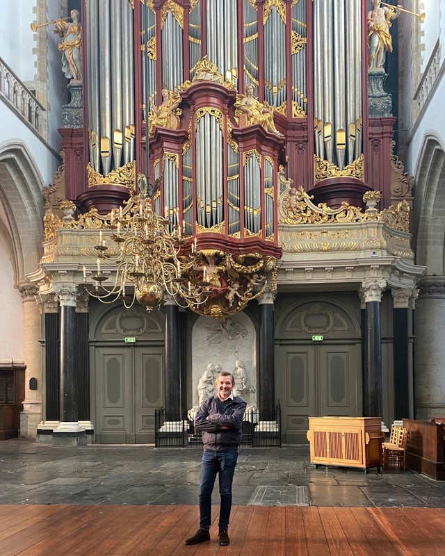 ein Mann steht vor einer imposanten Orgel ein Mann steht vor einer imposanten Orgel