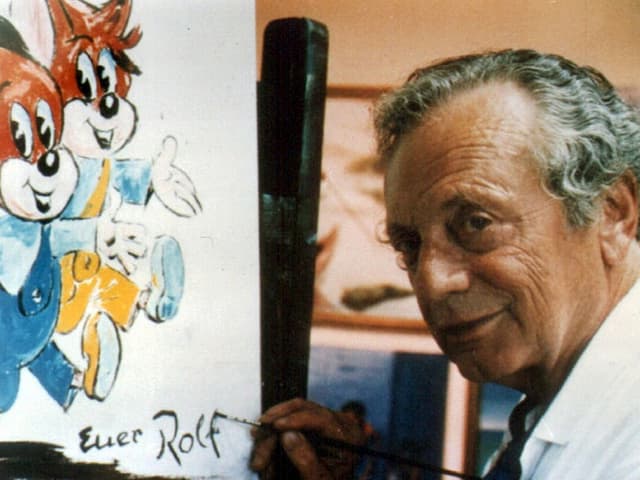 Rolf Kauka vor einem Bild von Fix und Foxi. Rolf Kauka vor einem Bild von Fix und Foxi.