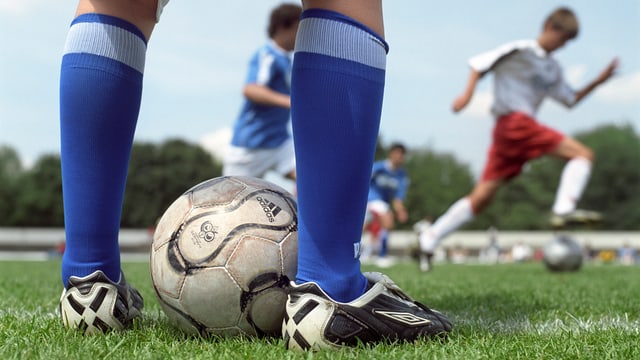 Kind mit Fussballerschuhen und Fussball Kind mit Fussballerschuhen und Fussball