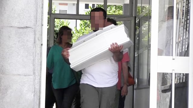 Vater trägt Sarg aus einer Türe. Vater trägt Sarg aus einer Türe.