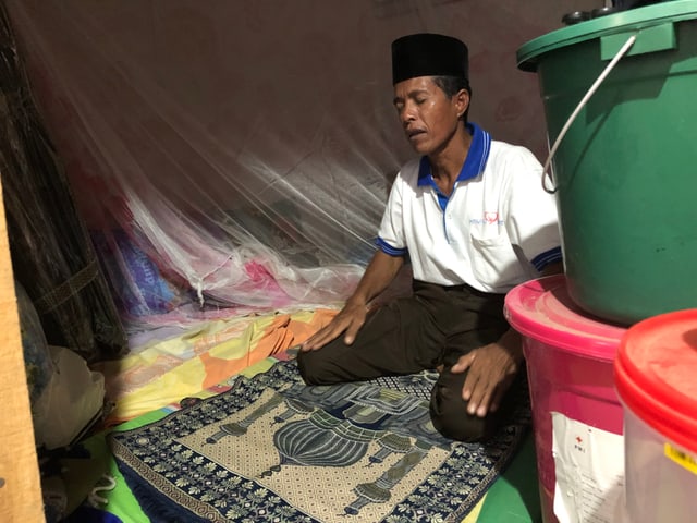 Indonesischer Mann kniet auf dem Boden und betet. Indonesischer Mann kniet auf dem Boden und betet.