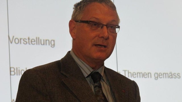 Porträtfoto von Urs-Martin Koch. Graue, kurze Haare, Brille, Anzug mit Krawatte. Porträtfoto von Urs-Martin Koch. Graue, kurze Haare, Brille, Anzug mit Krawatte.