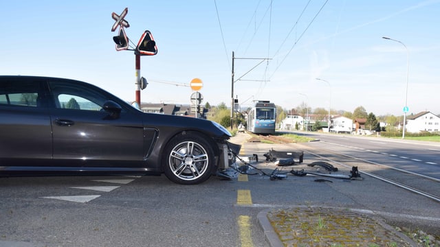 Porsche mit beschädigtem Frontbereich, Verschalung liegt am Boden, unweit der Bipperlisi-Gleise. Das Bähnli steht einige Meter weiter auf den Gleisen. Porsche mit beschädigtem Frontbereich, Verschalung liegt am Boden, unweit der Bipperlisi-Gleise. Das Bähnli steht einige Meter weiter auf den Gleisen.