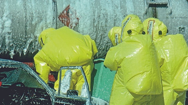 Feuerwehrleute in gelben Schutzanzügen. Feuerwehrleute in gelben Schutzanzügen.