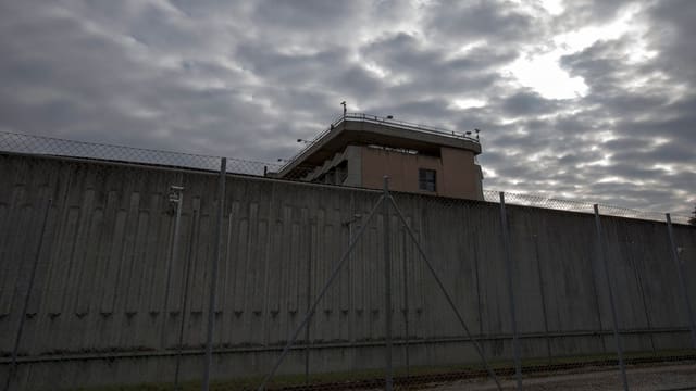 Eine Aufnahme einer hohen, grauen Mauer eines Gefängnisses. Eine Aufnahme einer hohen, grauen Mauer eines Gefängnisses.
