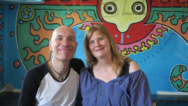 Ein Mann und eine Frau vor einer bunten Wand Ein Mann und eine Frau vor einer bunten Wand