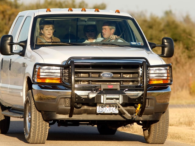 US-Präsident G. W. Bush fährt Angela Merkel 2007 von der Landepiste in Camp David zum Landhaus. (keystone)