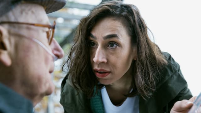 Eine junge Frau im Gespräch mit einem alten Mann. Eine junge Frau im Gespräch mit einem alten Mann.