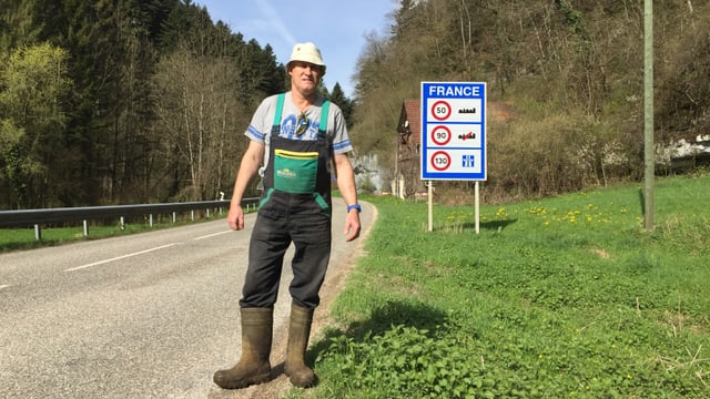 Bauer neben Strassenschild "France" Bauer neben Strassenschild "France"