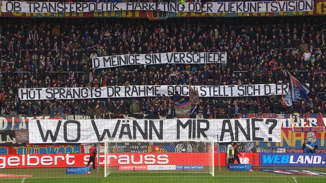 Spruchband: «Ob Transferpolitik oder Zuekunftsvision, d Meinige sin verschiede; hüt sprängts dr Rahme, doch stellt sich d Frog: Wo wänn mir ane?» Spruchband: «Ob Transferpolitik oder Zuekunftsvision, d Meinige sin verschiede; hüt sprängts dr Rahme, doch stellt sich d Frog: Wo wänn mir ane?»