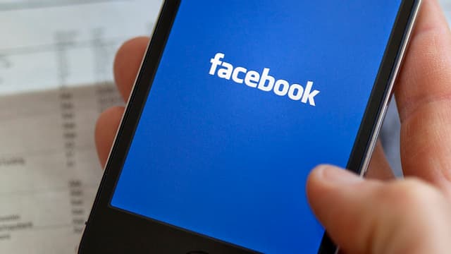 Ein Smartphone mit dem Facebook-Logo im Display. Ein Smartphone mit dem Facebook-Logo im Display.