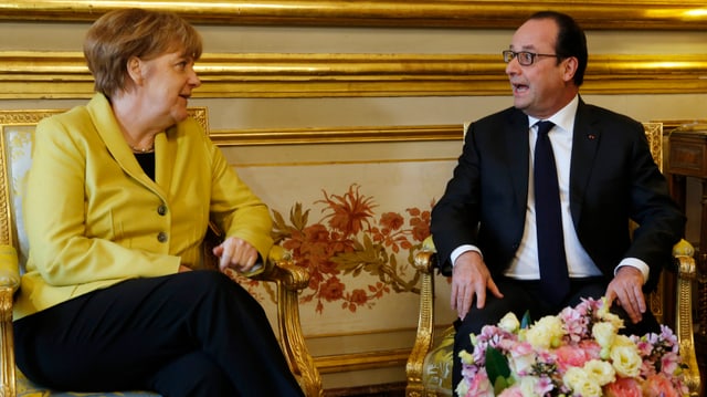 Merkel und Hollande sitzen nebeneinander Merkel und Hollande sitzen nebeneinander