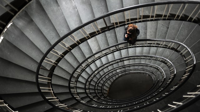 Frau läuft auf einer Wendeltreppe Frau läuft auf einer Wendeltreppe