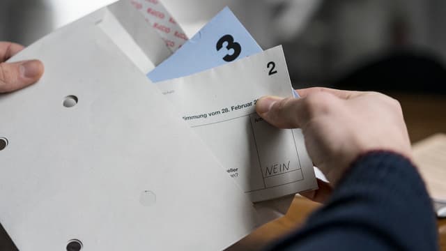 Hand hält Papier und Couvert. Hand hält Papier und Couvert.