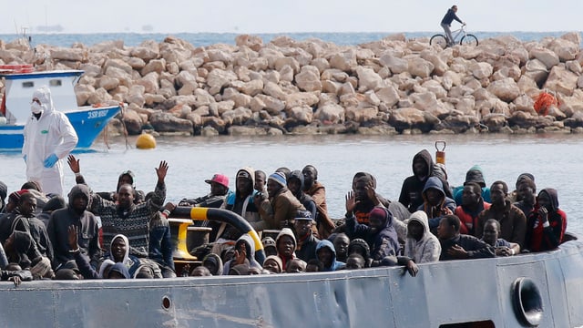 Von der italienischen Marine gerettete Flüchtlinge kommen auf Sizilien an. Von der italienischen Marine gerettete Flüchtlinge kommen auf Sizilien an.