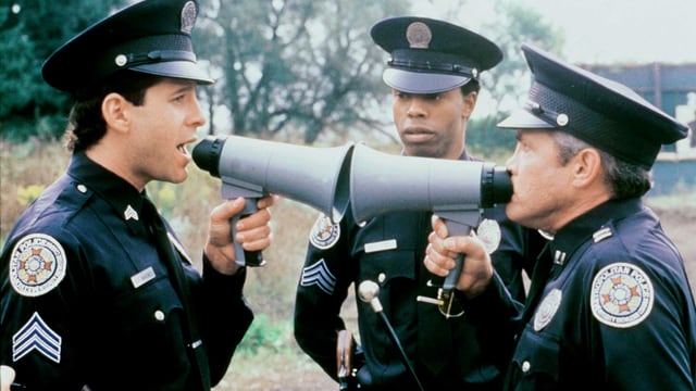 Filmszene Zwei Polizisten sprechen aus nächster Distanz durch zwei Megaphone miteinander Filmszene Zwei Polizisten sprechen aus nächster Distanz durch zwei Megaphone miteinander