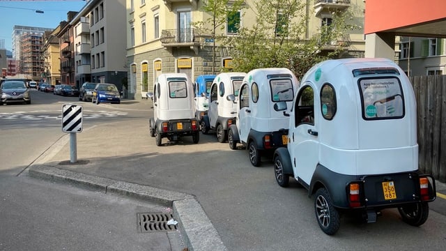 Kleine weisse Autos stehen auf dem Trottoir Kleine weisse Autos stehen auf dem Trottoir