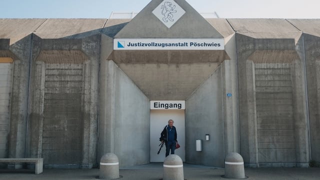 Betonfassade eines Gebäudes, ein Mann steht vor einer Tür mit grossen Schild "EinganG". Betonfassade eines Gebäudes, ein Mann steht vor einer Tür mit grossen Schild "EinganG".