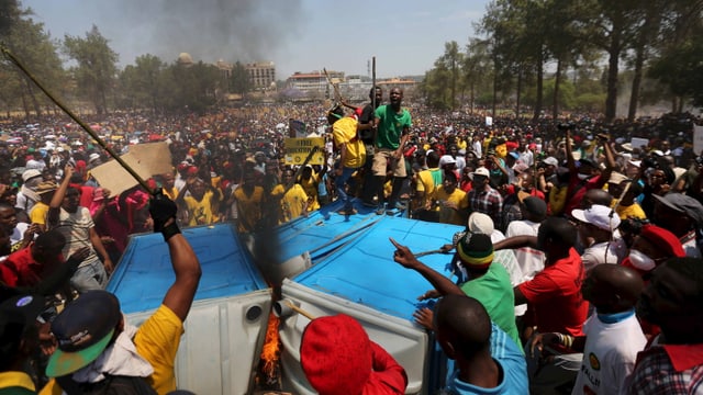 Brennende WC-Häuschen und wütende Studenten vor dem Regierungssitz in Pretoria. Brennende WC-Häuschen und wütende Studenten vor dem Regierungssitz in Pretoria.